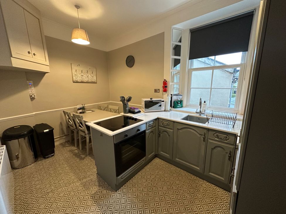 A kitchen with appliances and dining table at The Teviot in Kelso