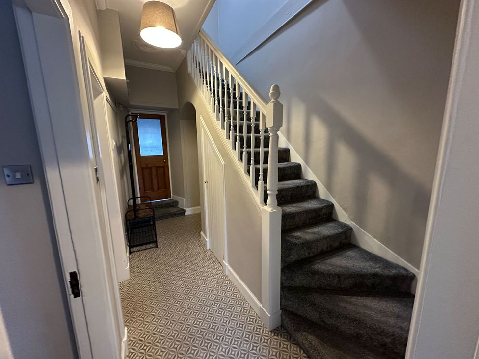 A hallway with stairs and a front door at The Teviot in Kelso