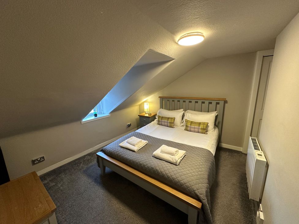 A bedroom with a bed and window at The Teviot in Kelso