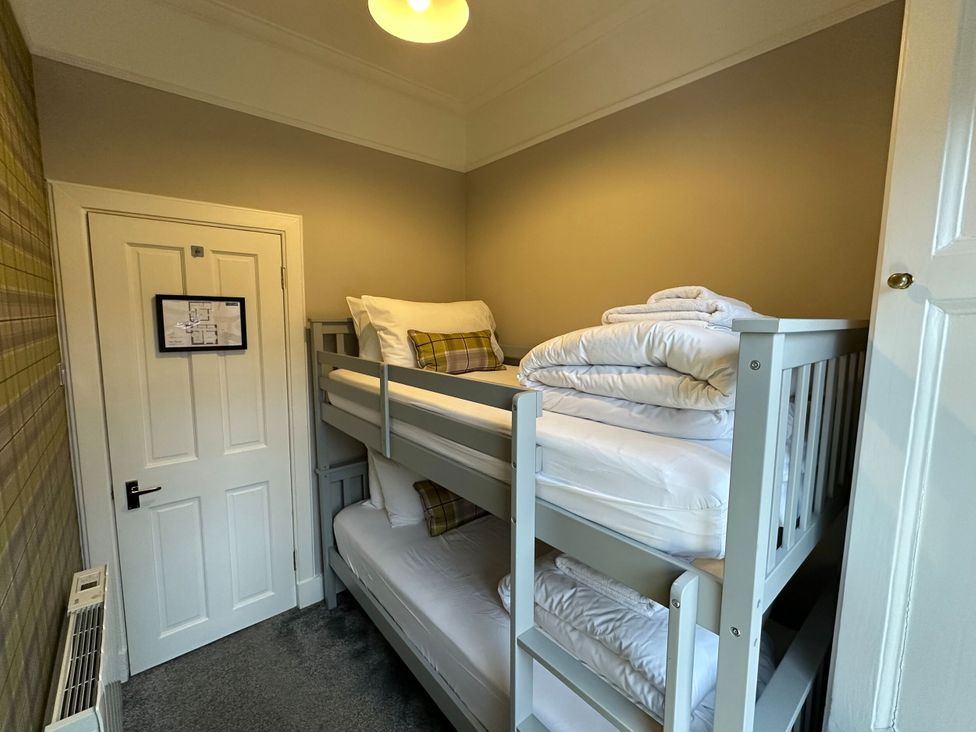A bedroom with a bunk bed and a door at The Teviot in Kelso