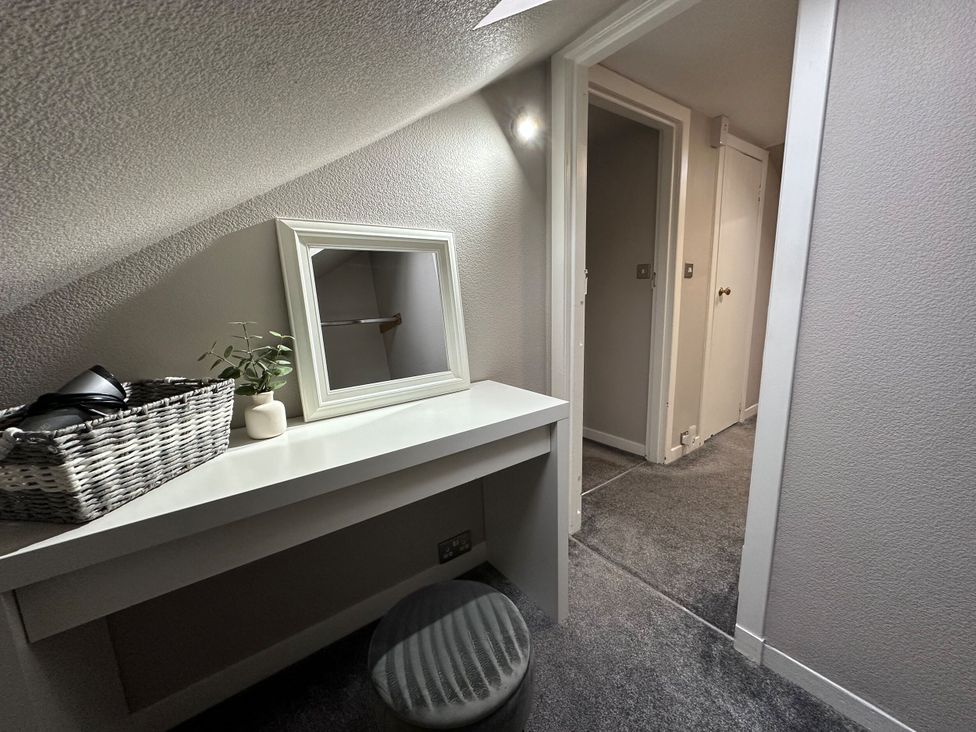 A hallway with a mirror and storage basket at The Teviot in Kelso