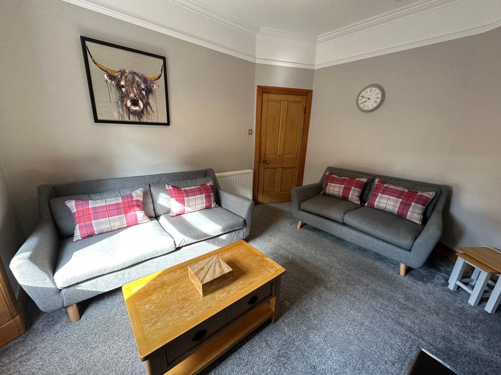 A living room with sofas and a clock at The Tweed in Melrose