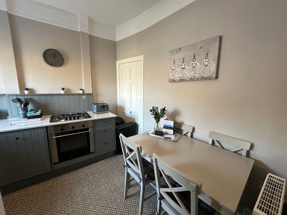 A kitchen with a gas stove and a dining table at The Tweed in Melrose