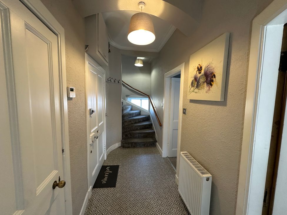 A hallway with stairs and a radiator at The Tweed in Melrose