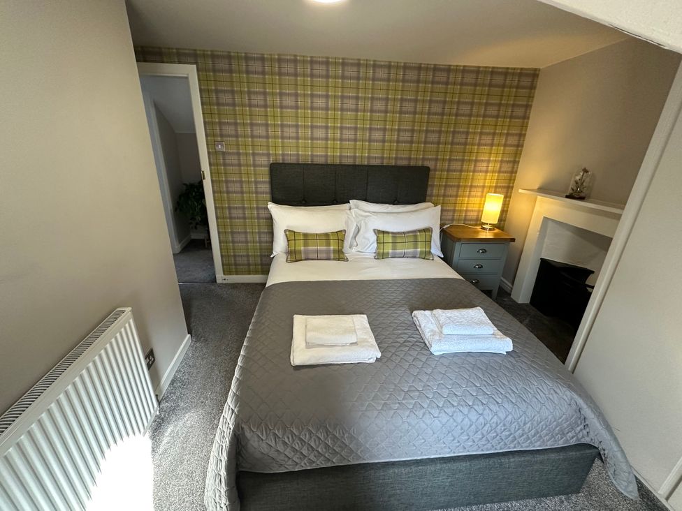A bedroom with a double bed and nightstand at The Tweed in Melrose