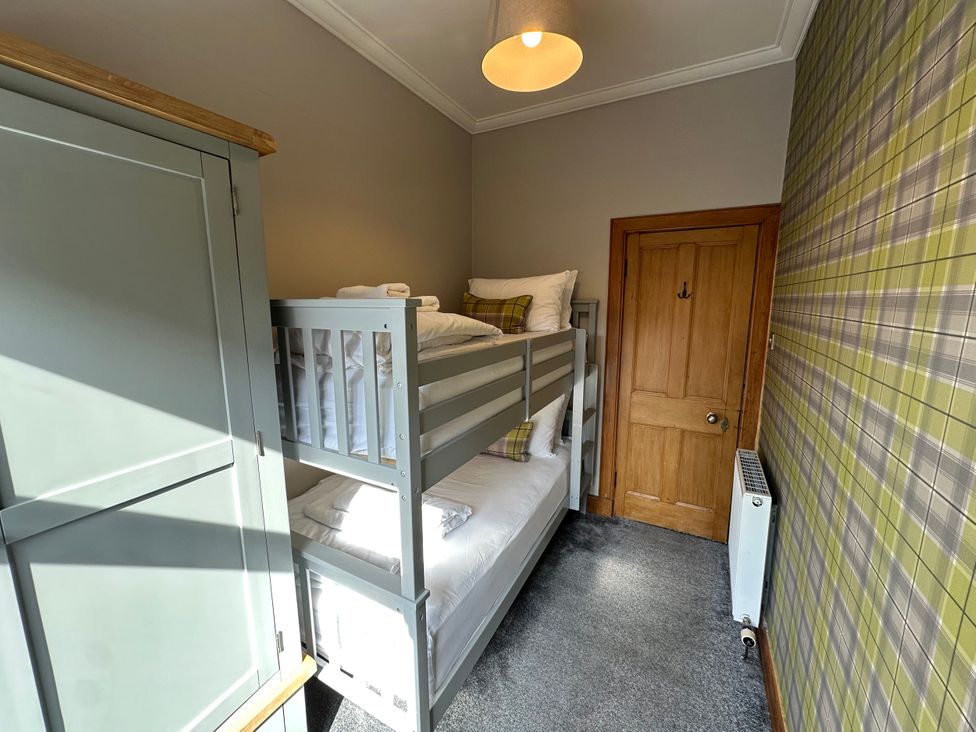 A bedroom with a bunk bed and wardrobe at The Tweed in Melrose