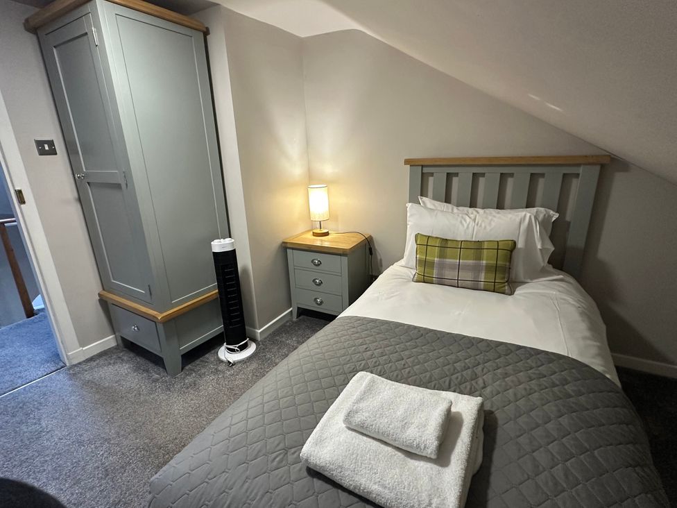 A bedroom with a single bed and wardrobe at The Tweed in Melrose