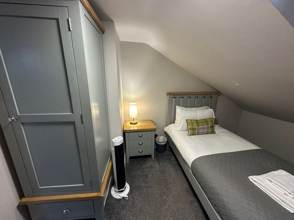 A bedroom with a bed and wardrobe at The Tweed in Melrose