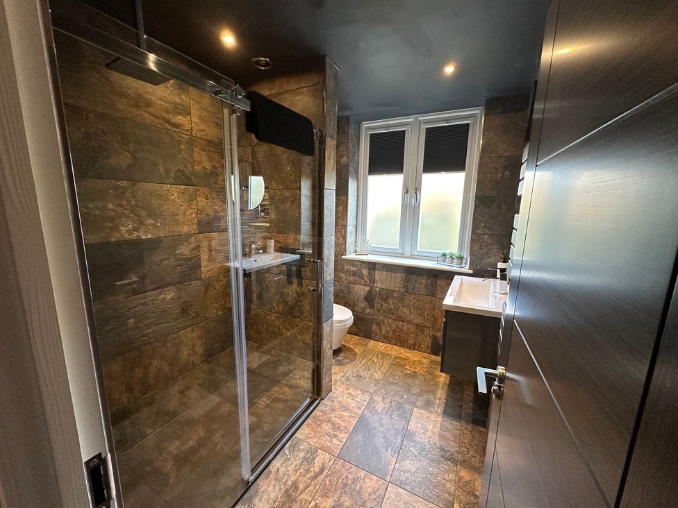 A bathroom with a shower, toilet, and sink at The Tay in Melrose