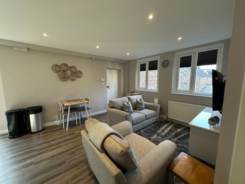 A living room with a sofa and television at The Esk in Melrose