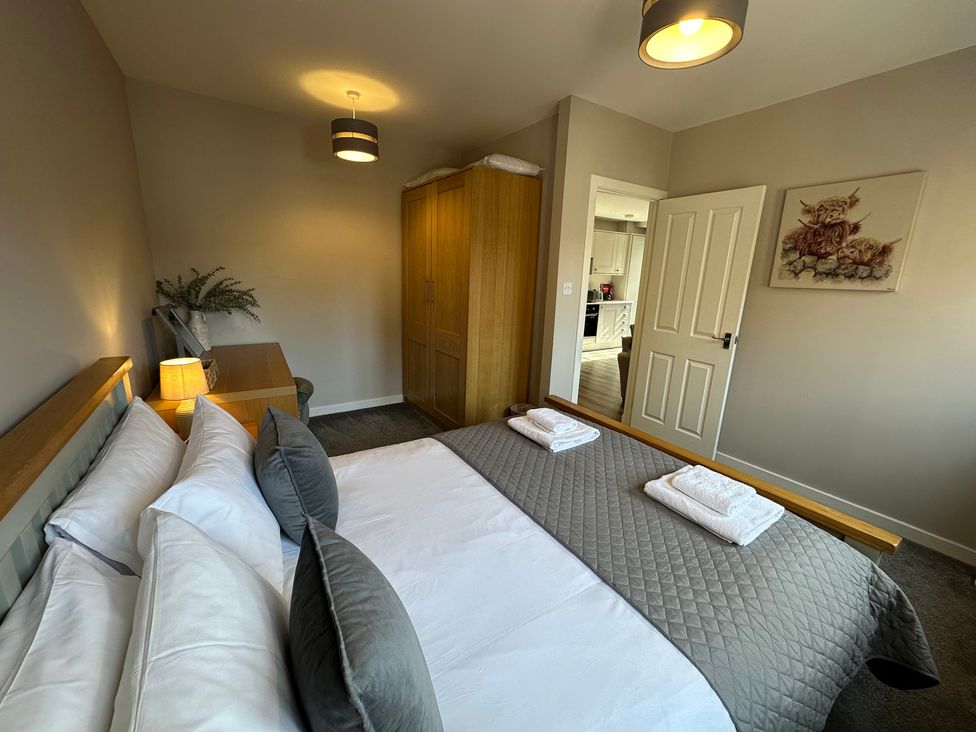 A bedroom with a bed and wardrobe at The Esk in Melrose