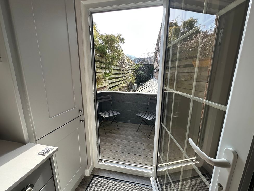 A balcony with two chairs and a sliding door at The Esk in Melrose