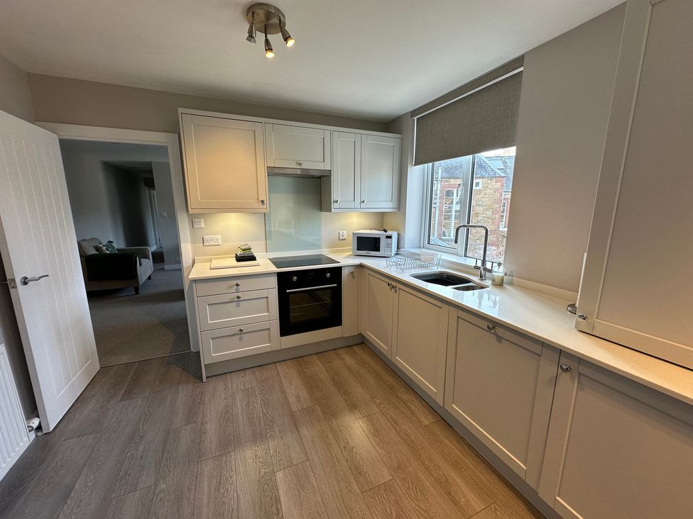 A kitchen with cabinets, stove, and microwave at The Clyde