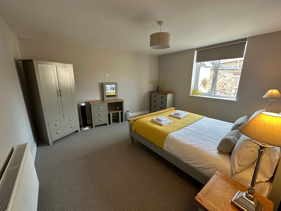 A bedroom with a bed, wardrobe, nightstand, and a window at The Clyde