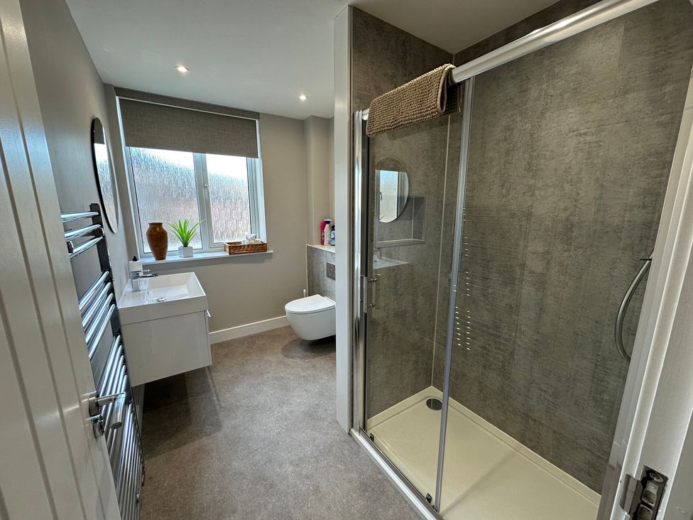 A bathroom with a shower, toilet, sink and window at The Clyde 