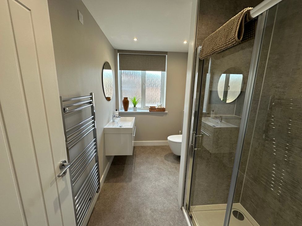 A bathroom with a shower, sink, and toilet at The Clyde