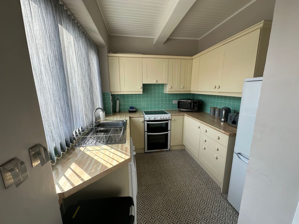 A kitchen with cabinets, stove, sink and appliances at Pergola in Melrose