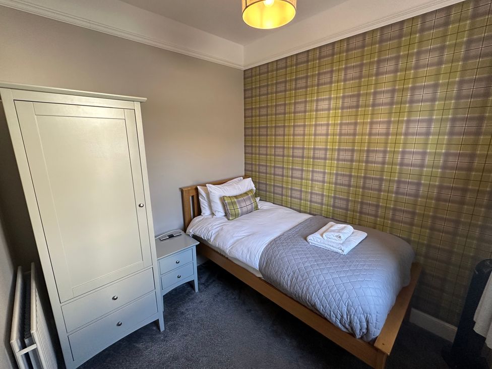 A bedroom with a single bed and wardrobe at Pergola in Melrose