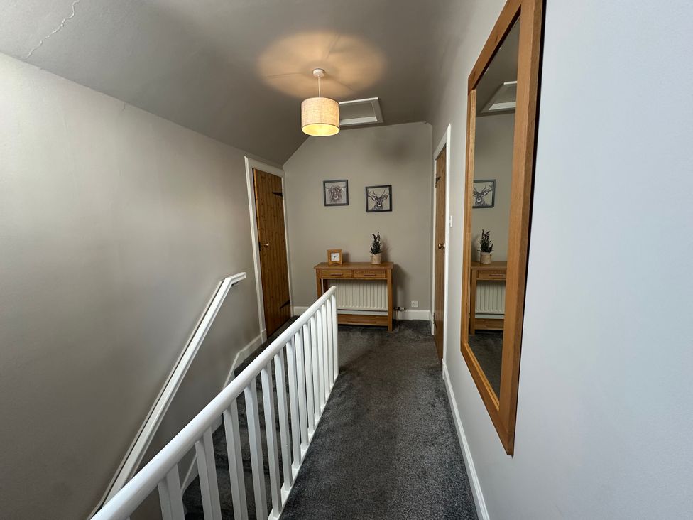 A hallway with a staircase and console table at Pergola in Melrose