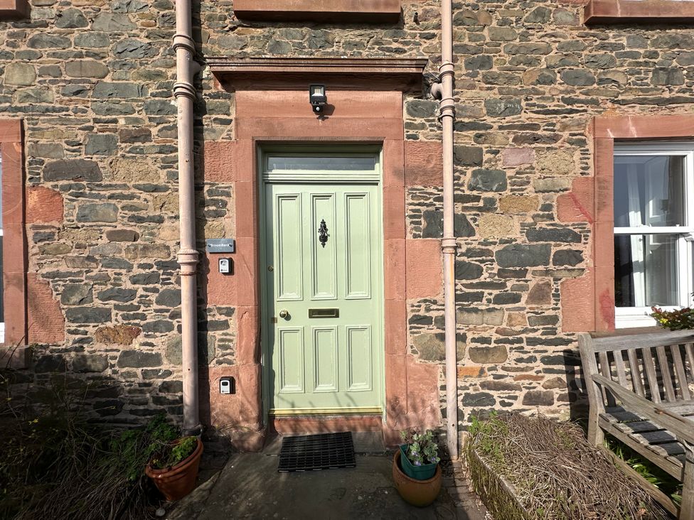 A front door with a stone wall and plant pot at Broombank in Melrose