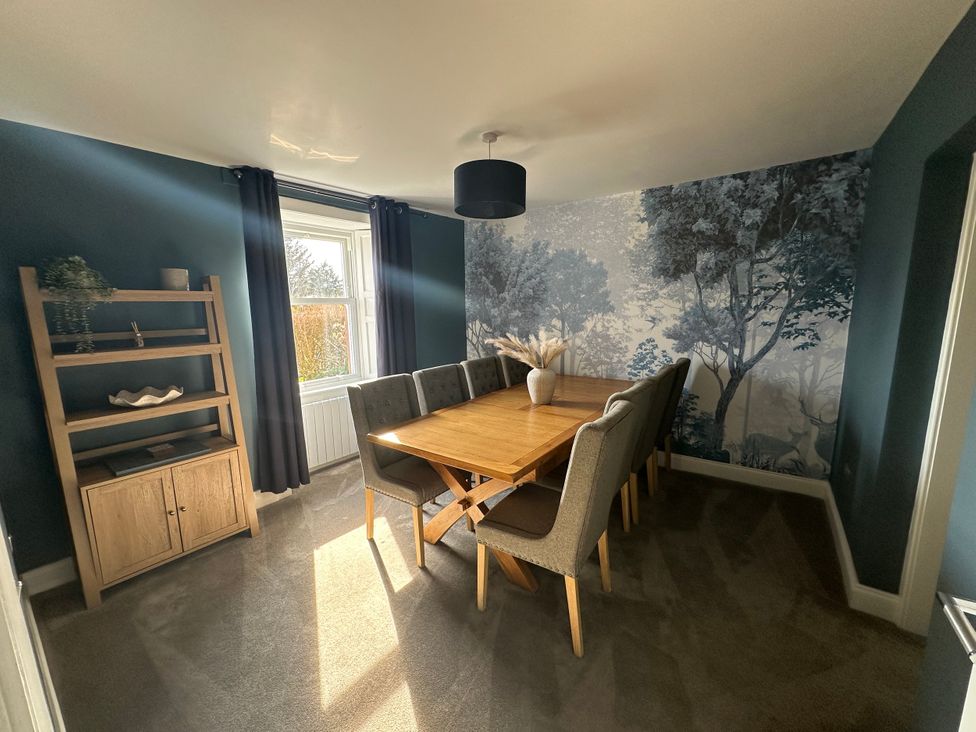 A dining room with a wooden table and chairs at Broombank in Melrose