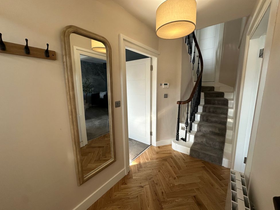 A hallway with a mirror and staircase at Broombank in Melrose