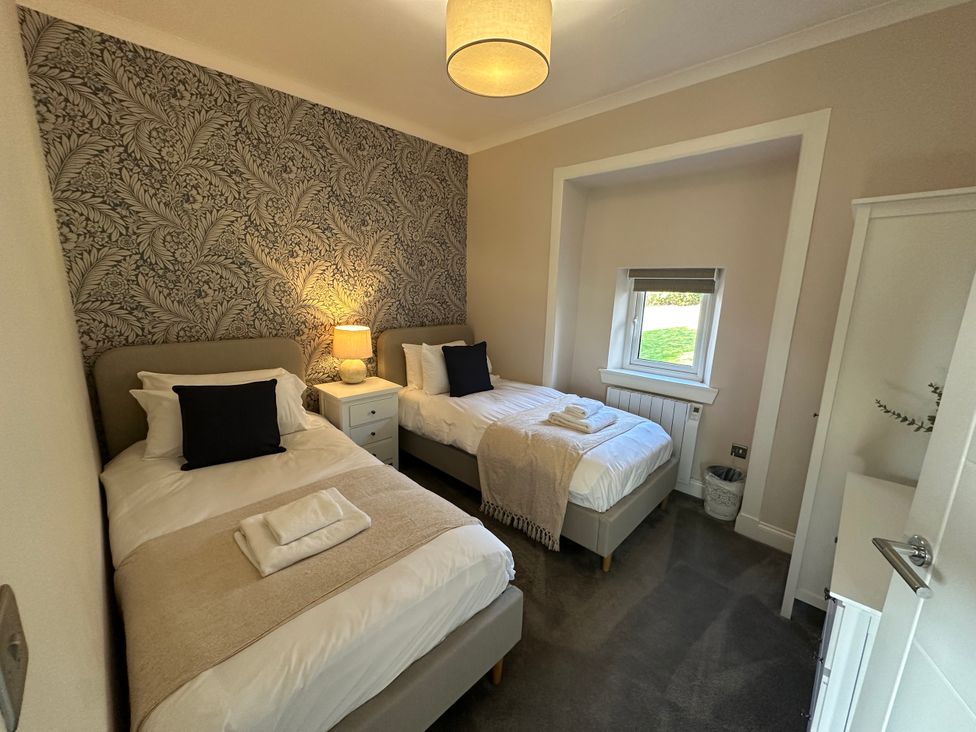 A bedroom with two single beds and a window at Broombank in Melrose