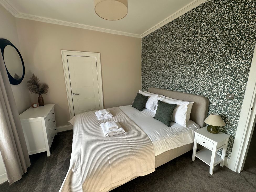 A bedroom with a bed and mirror at Broombank in Melrose