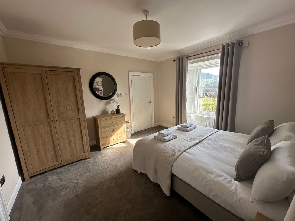 A bedroom with a bed and wardrobe at Broombank in Melrose