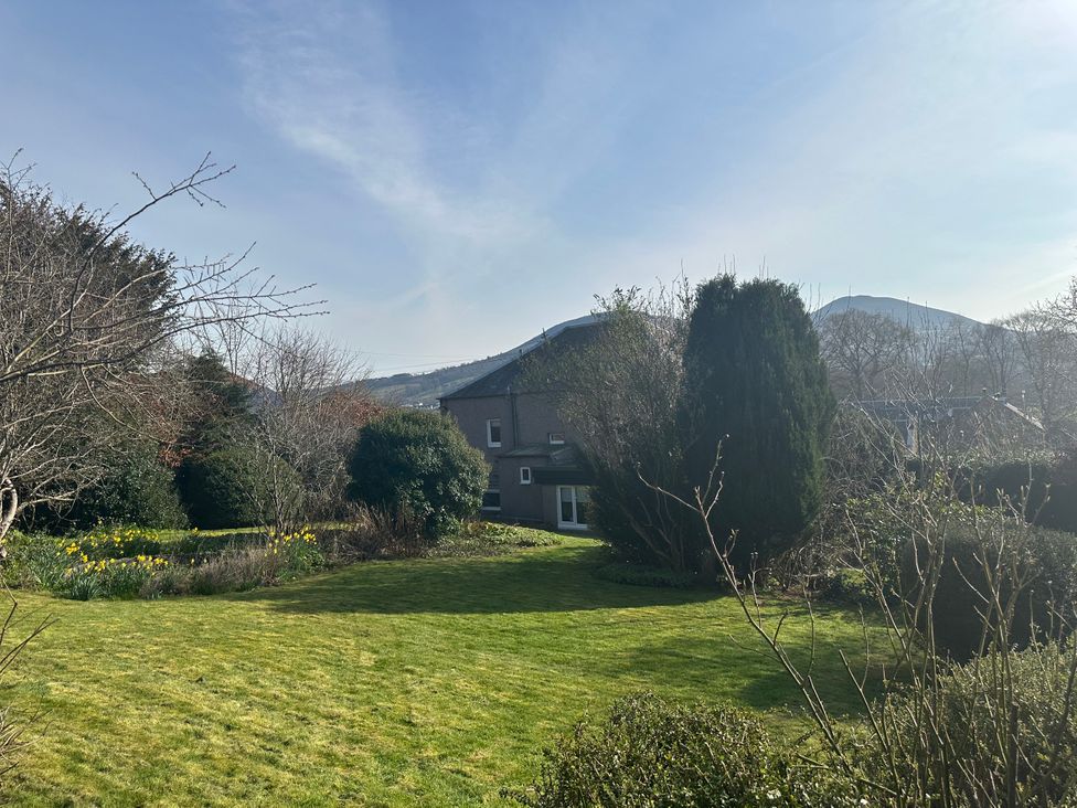 A garden with grass, trees, and flowers at Broombank in Melrose