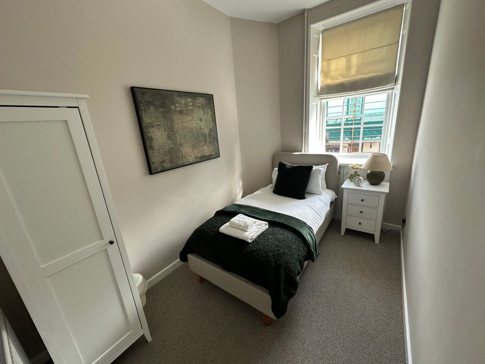 A bedroom with a single bed and wardrobe at Horsemarket in Kelso