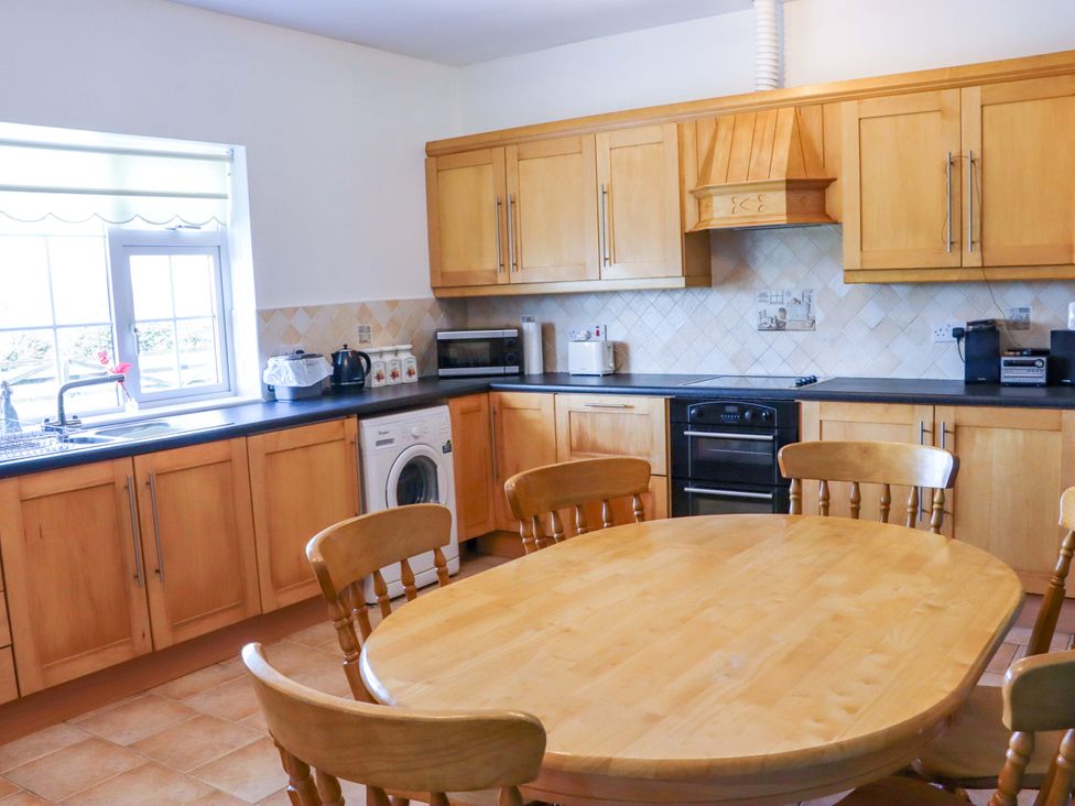 A kitchen with wooden cabinets and appliances at BREAGHMORE