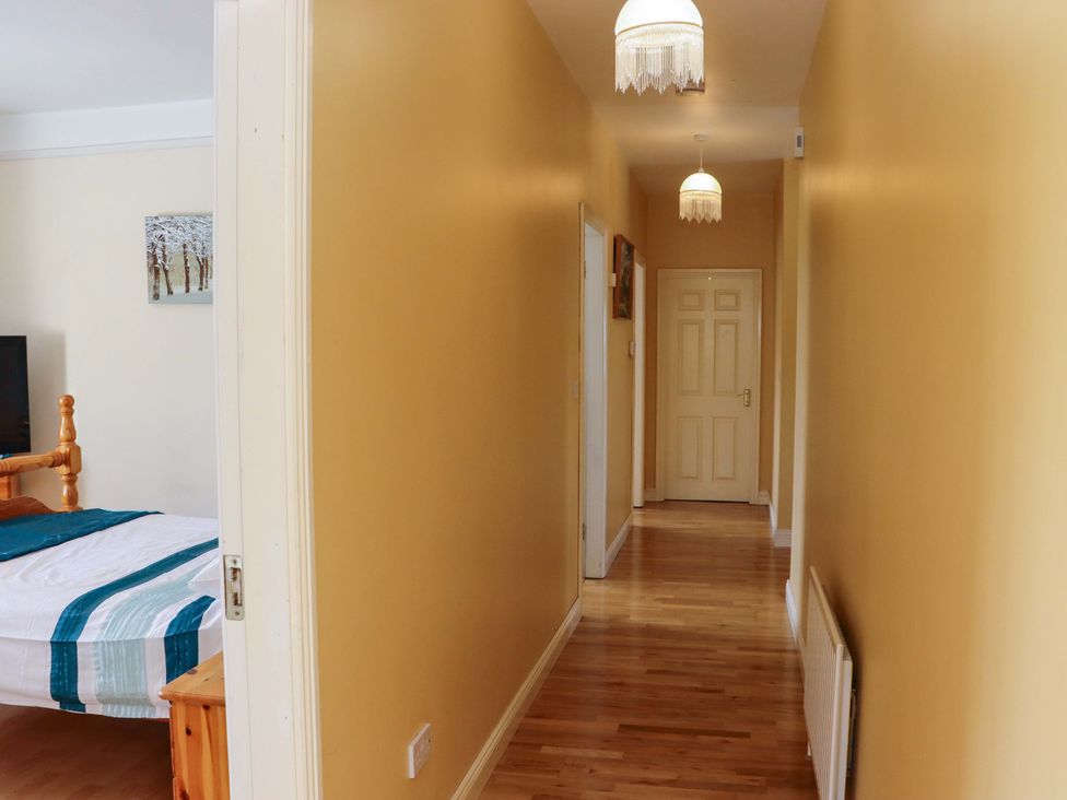 A hallway with a door and light fixtures at BREAGHMORE