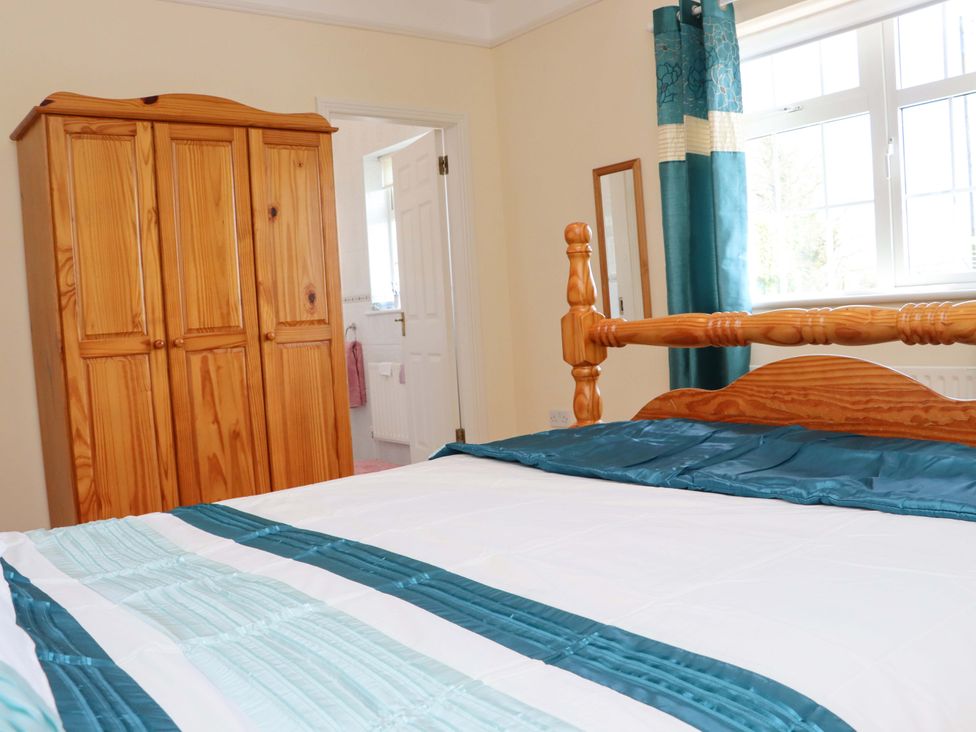 A bedroom with a bed and a wooden wardrobe at BREAGHMORE