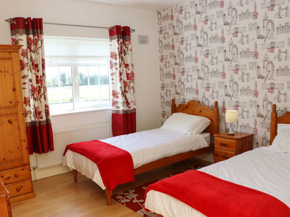 A bedroom with two single beds and a window at BREAGHMORE