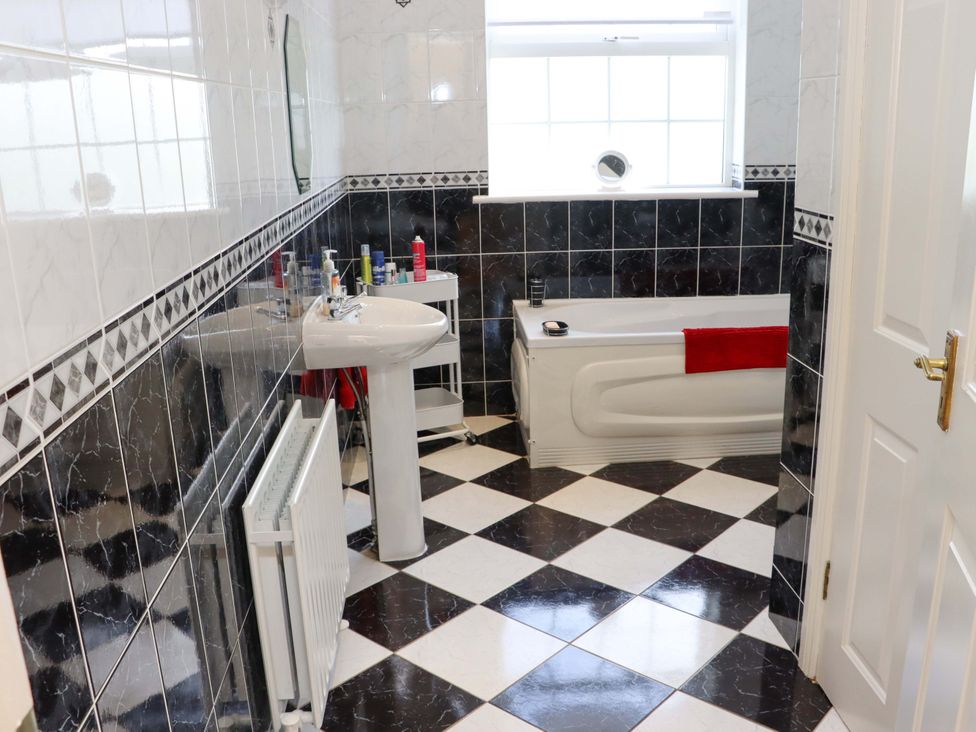 A bathroom with a bath tub and sink at BREAGHMORE