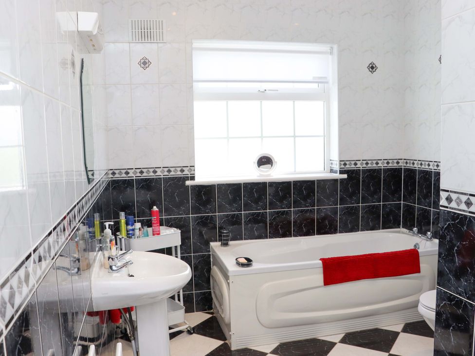 A bathroom with a bathtub, sink, and toilet at BREAGHMORE