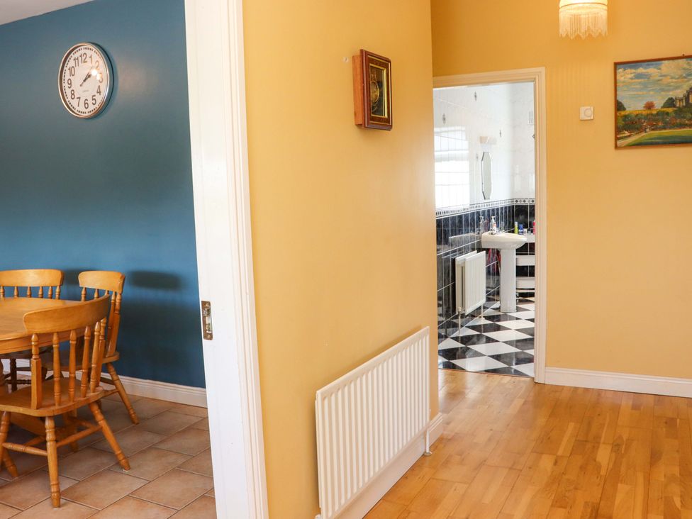 A dining room with table and chairs leading to a bathroom at BREAGHMORE