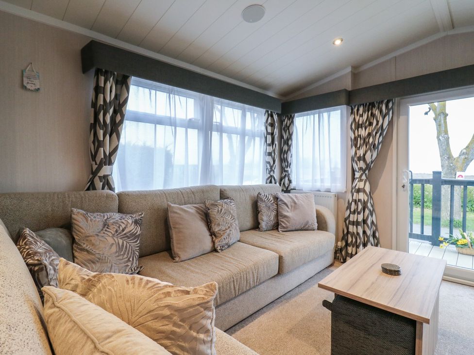 A living room with a sofa and coffee table at no 20 Barley Way in Colchester