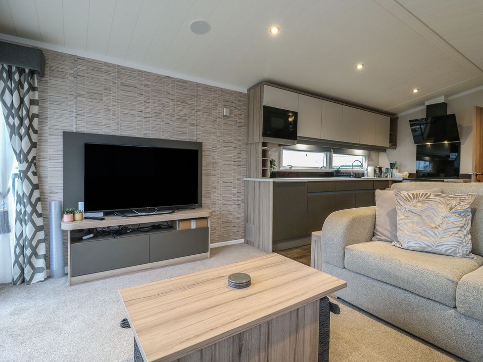 A living room with a television and coffee table at no 20 Barley Way in Colchester