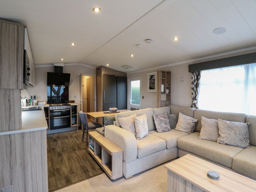 A living room with a sofa and dining area at no 20 Barley Way Colchester