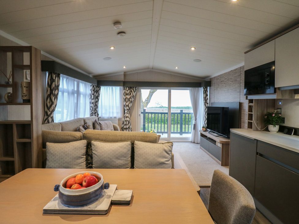 A living room with a sofa and table at no 20 Barley Way in Colchester