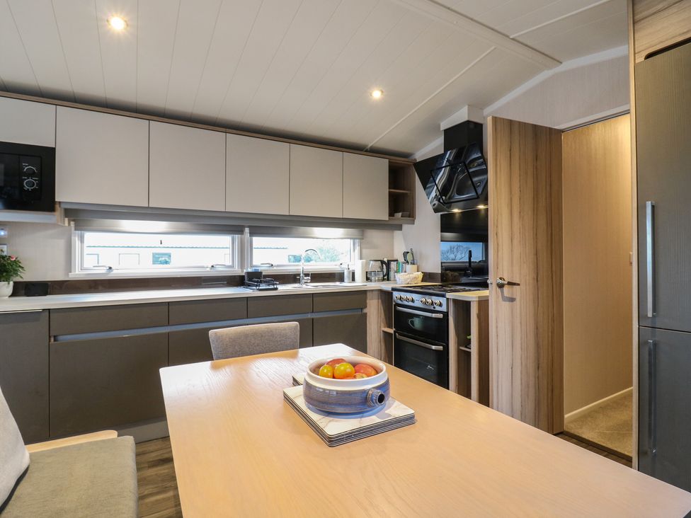 A kitchen with a dining table and fruit bowl at no 20 Barley Way in Colchester