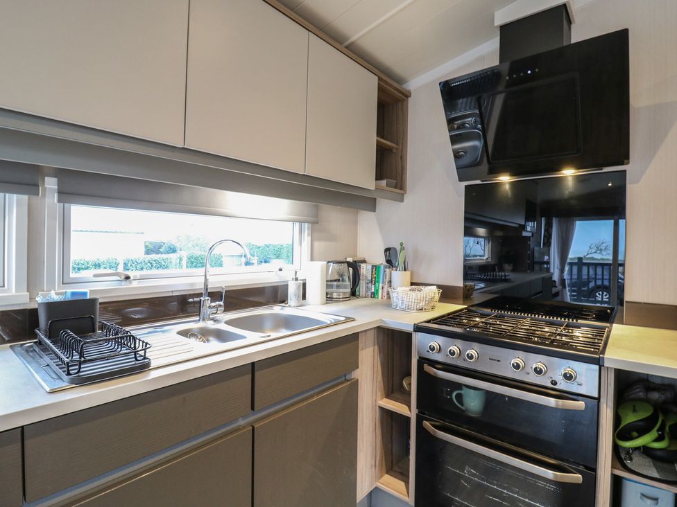 A kitchen with sink and stove at no 20 Barley Way in Colchester