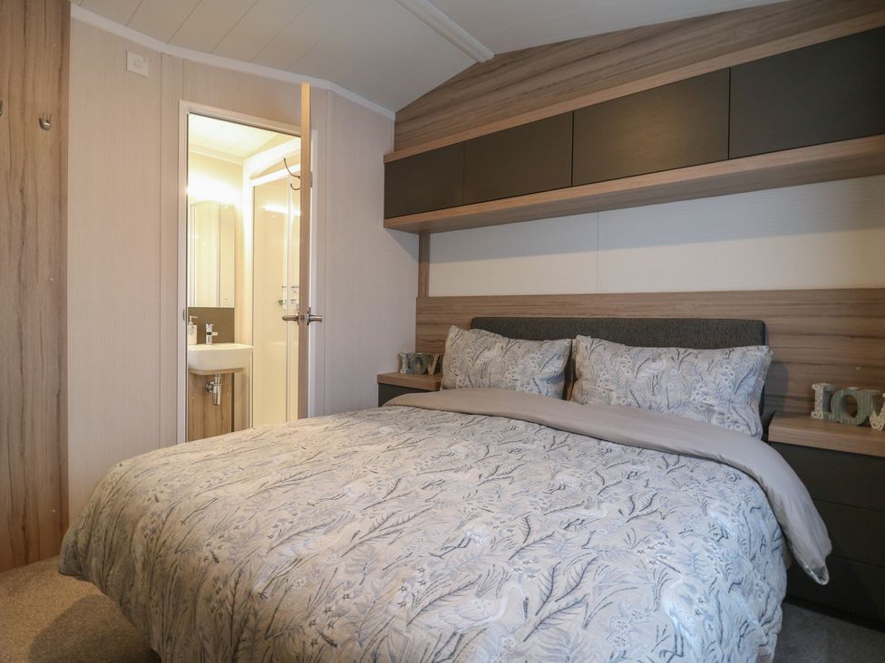A bedroom with a bed and adjacent bathroom at no 20 Barley Way Colchester