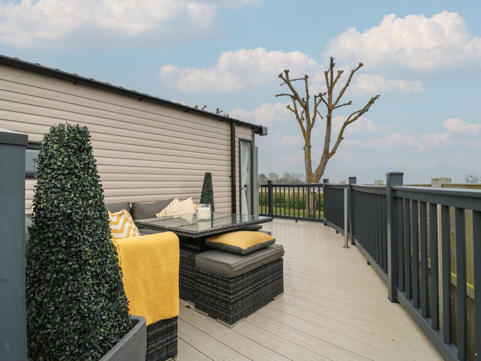 A deck with outdoor furniture and a potted plant at no 20 Barley Way in Colchester
