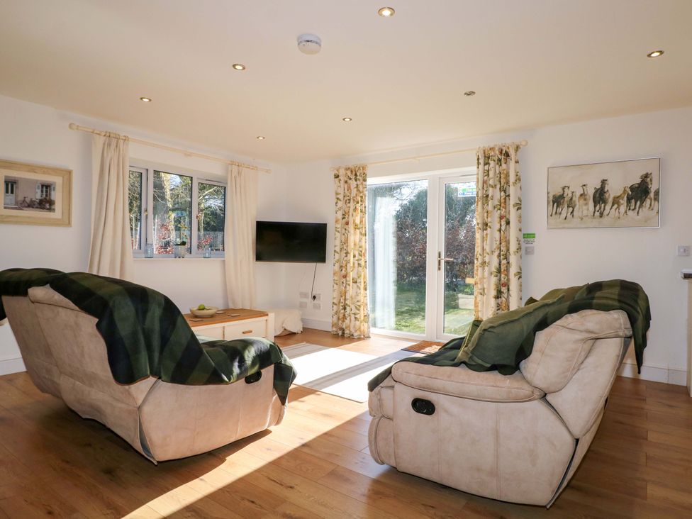 A living room with a sofa and a tv at Snowdrop Cottage Maidstone