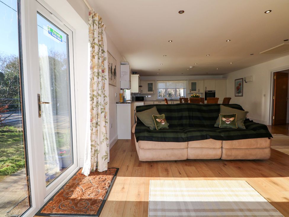 A living room with a sofa and kitchen space at Snowdrop Cottage Maidstone