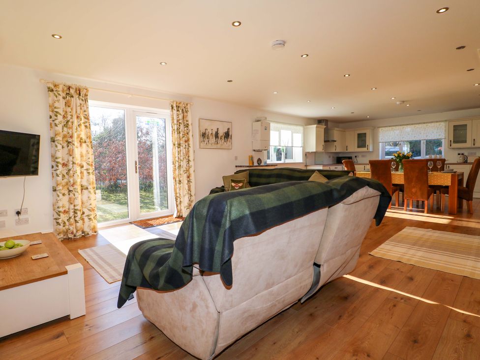 A living room with kitchen area and dining space at Snowdrop Cottage in Maidstone