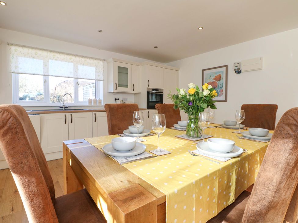 A dining room with a table set for dinner at Snowdrop Cottage in Maidstone